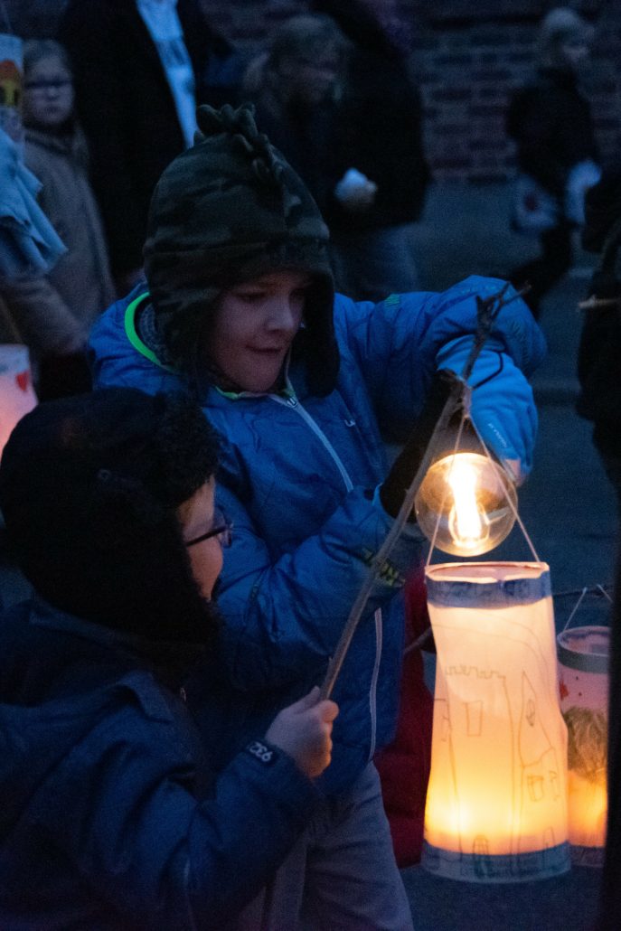 Deux enfants allumant des lanternes